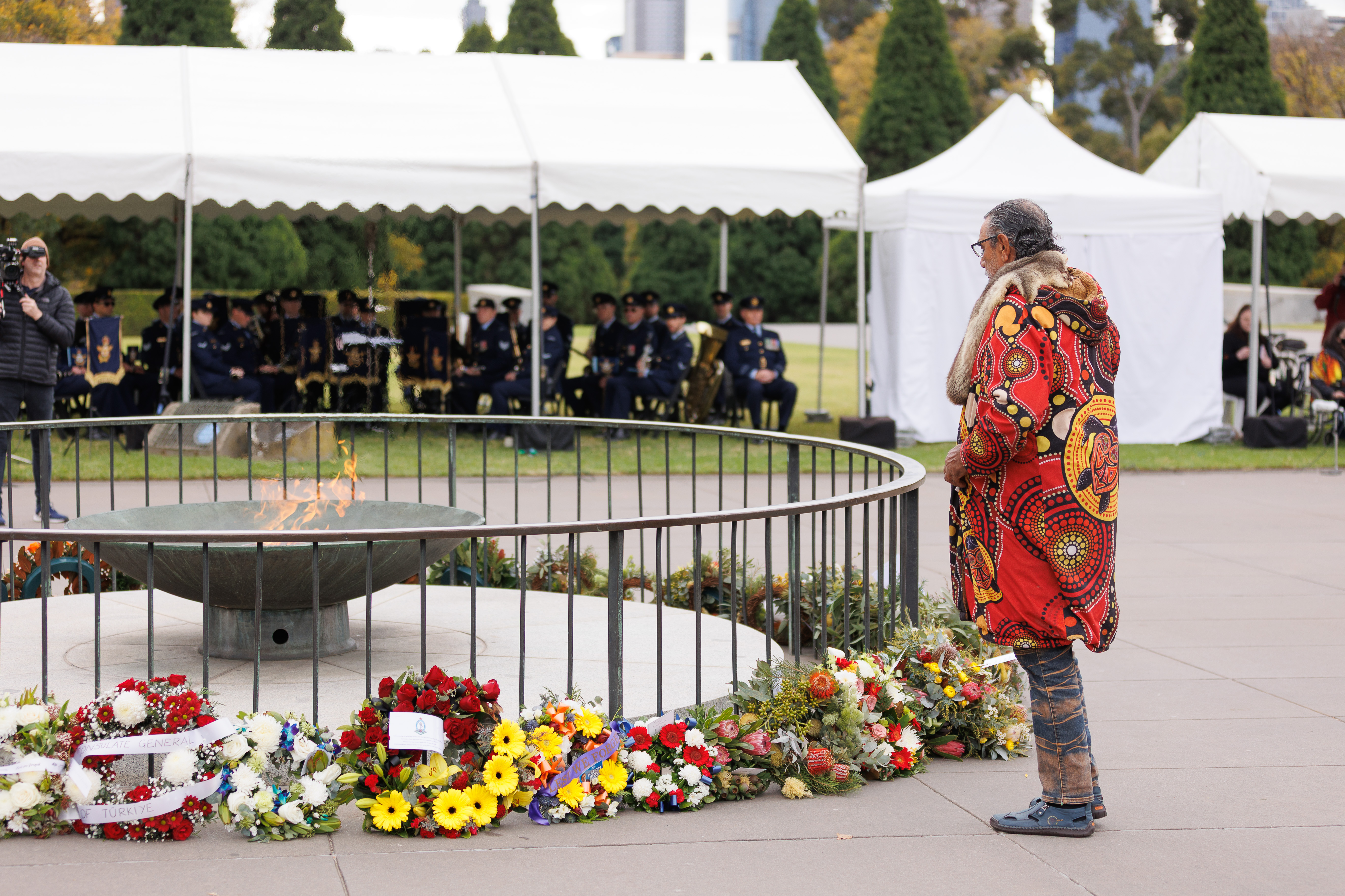 Bunurong Elder Uncle Mick Edwards stands beside the Shrine of Remembrance cauldron 